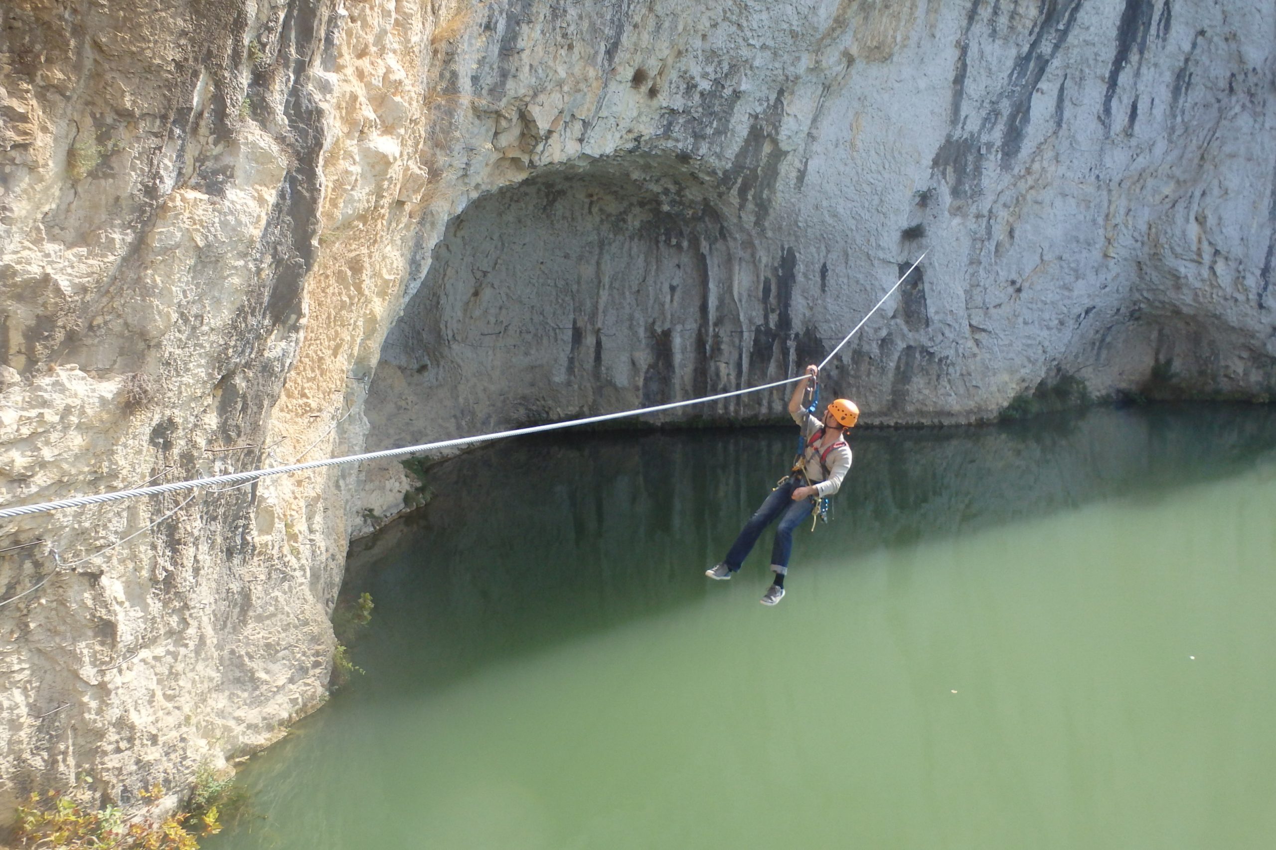 Via ferrata près de Montpellier dans l’Hérault, tyrolienne au-dessus d’une rivière au pied des falaises