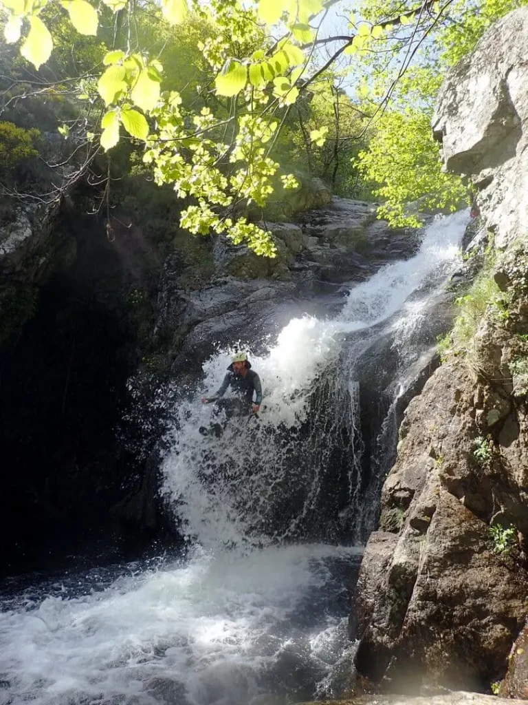 Canyoning près de Montpellier : passage de cascade en combinaison et casque, photo souvenir de la sortie